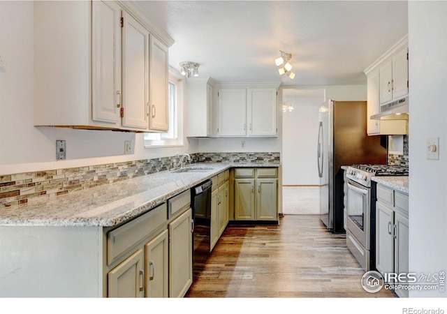 kitchen featuring black dishwasher, sink, light stone countertops, and stainless steel range oven