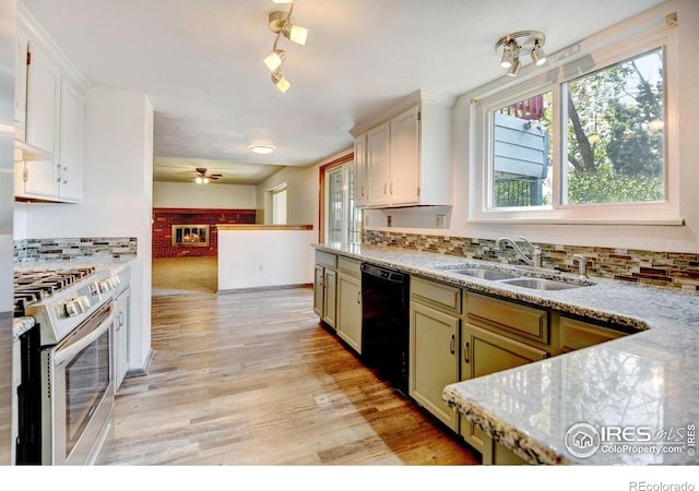 kitchen featuring dishwasher, stainless steel stove, a healthy amount of sunlight, and sink