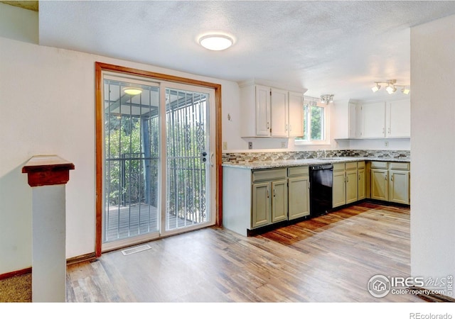 kitchen featuring green cabinets, sink, light wood-type flooring, black dishwasher, and tasteful backsplash