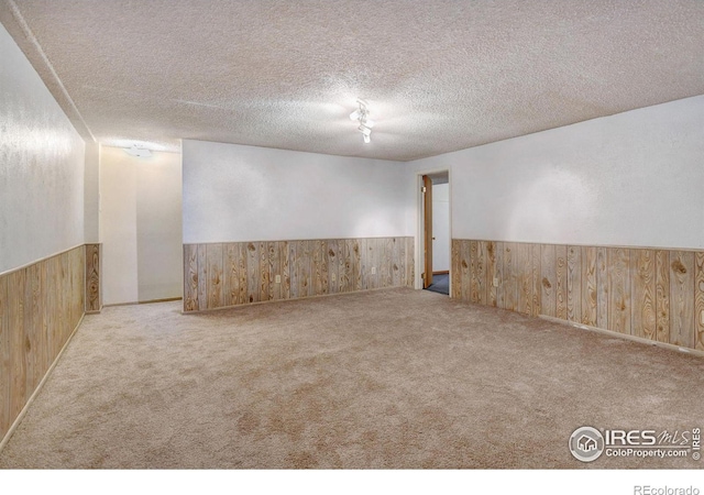 unfurnished room featuring a textured ceiling and light carpet