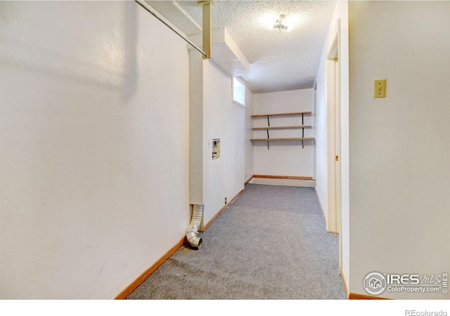 corridor with a textured ceiling and carpet floors