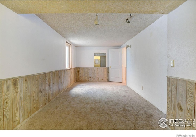 spare room featuring light carpet and a textured ceiling