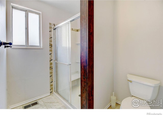 bathroom featuring toilet and an enclosed shower