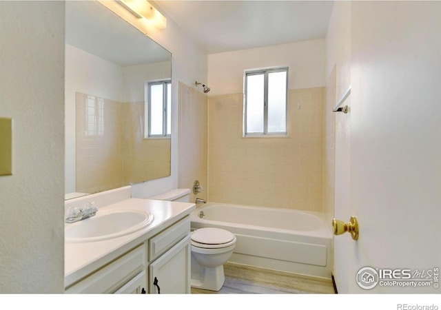 full bathroom featuring plenty of natural light, vanity, tiled shower / bath combo, and toilet