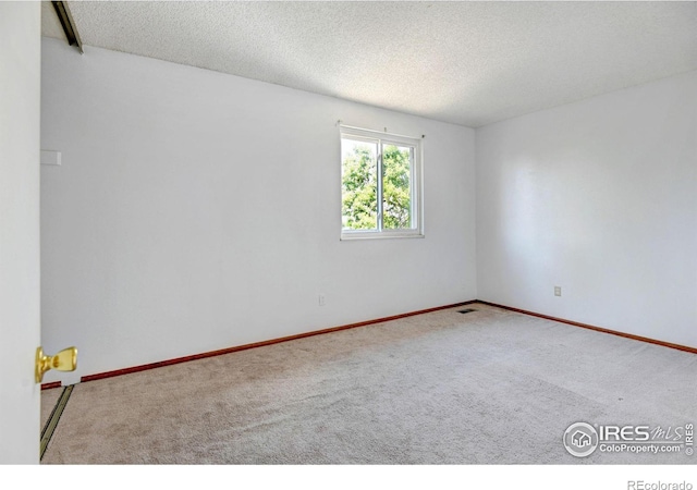 empty room with carpet flooring and a textured ceiling