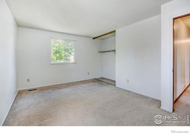 carpeted spare room featuring a textured ceiling