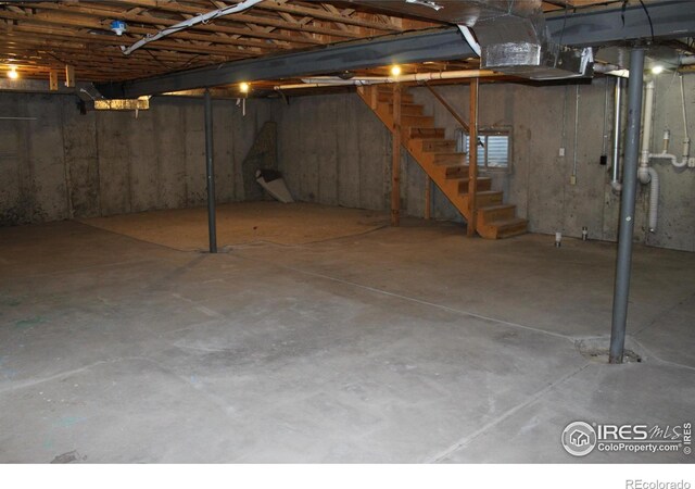 unfinished basement featuring stairway