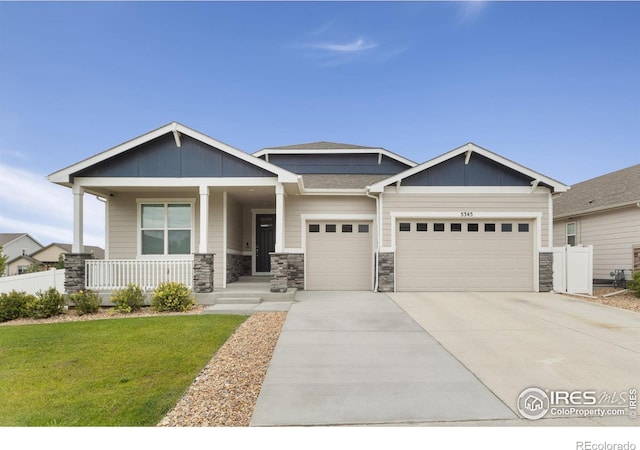 craftsman house with covered porch, a garage, and a front yard