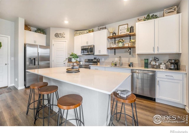 kitchen with white cabinets, stainless steel appliances, and a kitchen island