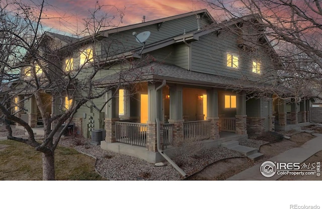 property exterior at dusk with covered porch and central air condition unit