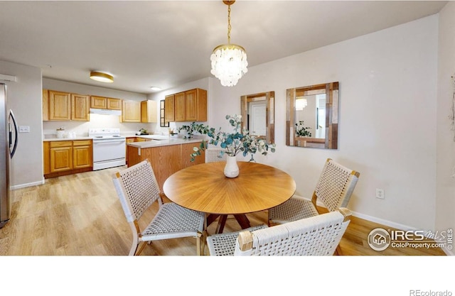 dining space featuring an inviting chandelier and light hardwood / wood-style floors