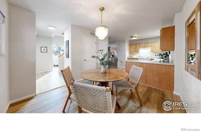 dining space featuring a chandelier and light hardwood / wood-style flooring