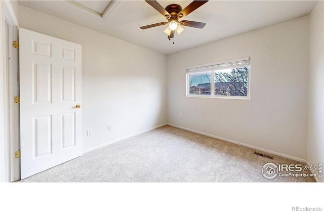 carpeted spare room with ceiling fan