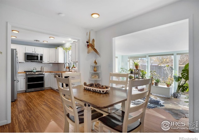 dining space featuring light hardwood / wood-style floors, a healthy amount of sunlight, and sink