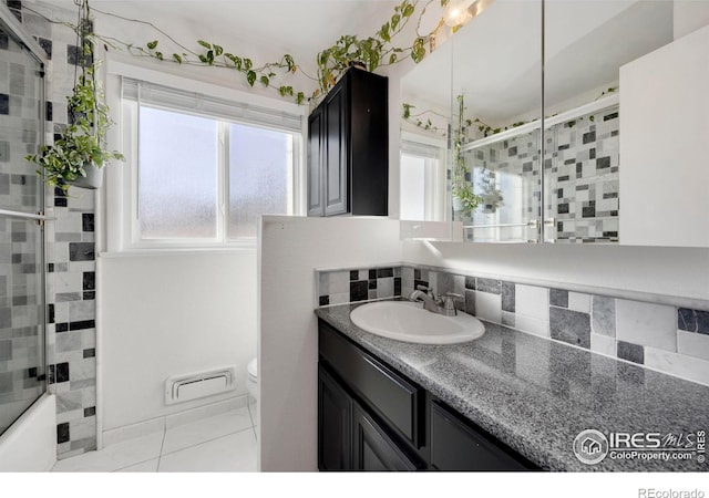 full bathroom with tasteful backsplash, tile patterned floors, vanity, shower / bath combination with glass door, and toilet