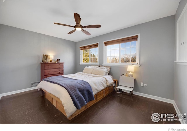 bedroom with ceiling fan, dark hardwood / wood-style floors, and a baseboard heating unit