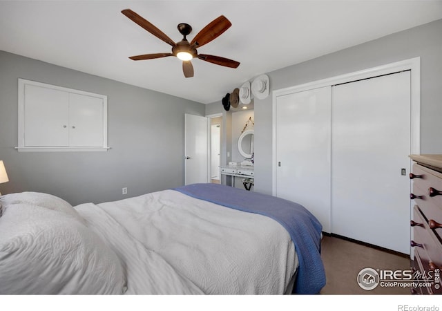 carpeted bedroom with ensuite bath, ceiling fan, and a closet