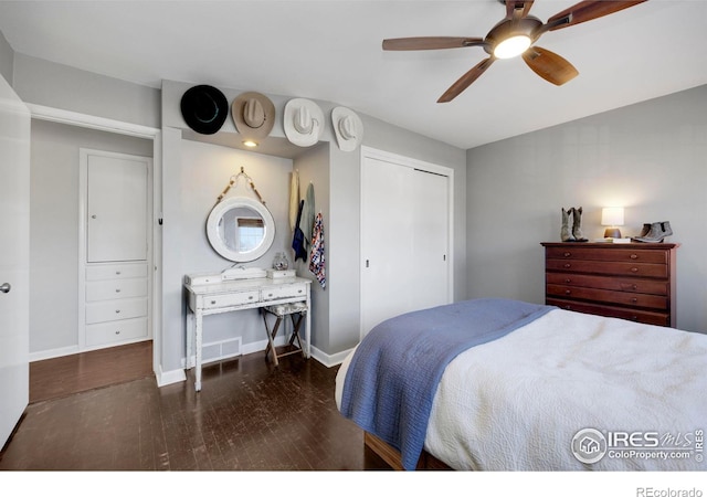 bedroom with ceiling fan, dark wood-type flooring, and a closet