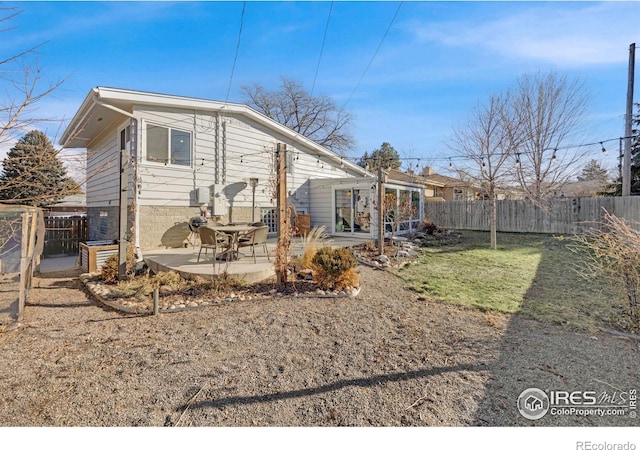 rear view of property with a patio and a lawn