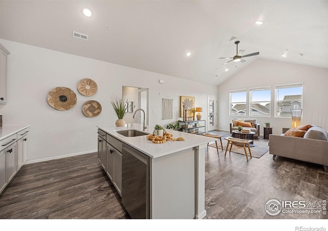 kitchen with ceiling fan, sink, dark hardwood / wood-style floors, an island with sink, and vaulted ceiling