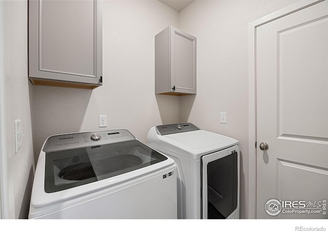 washroom featuring washing machine and dryer and cabinets