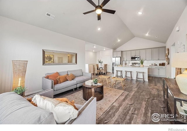 living room featuring ceiling fan, high vaulted ceiling, and dark hardwood / wood-style floors