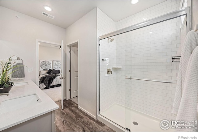 bathroom featuring hardwood / wood-style flooring, vanity, and walk in shower