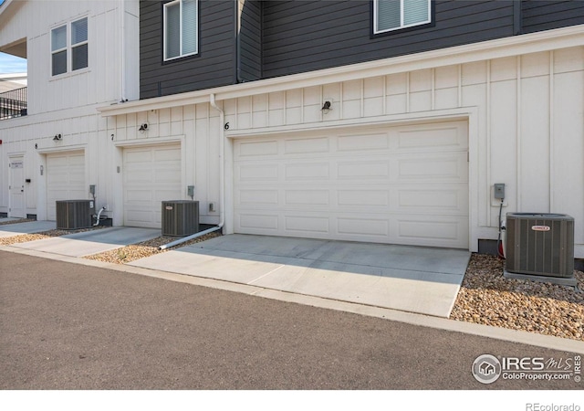 garage featuring concrete driveway and central AC