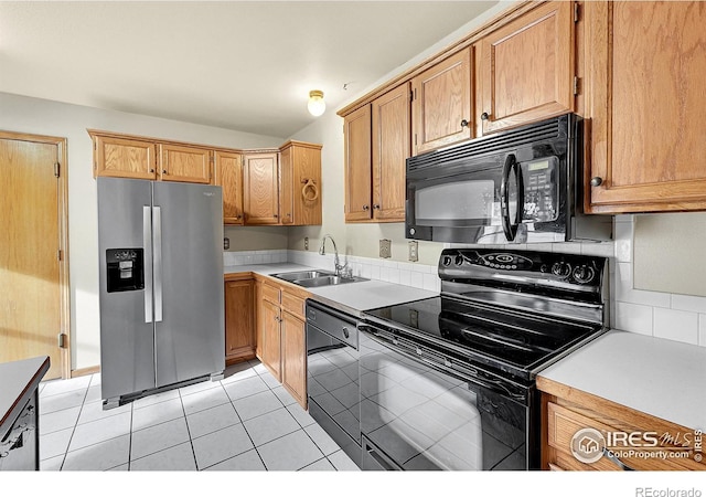 kitchen with light tile patterned floors, sink, and black appliances