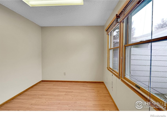 empty room featuring light hardwood / wood-style flooring and a textured ceiling