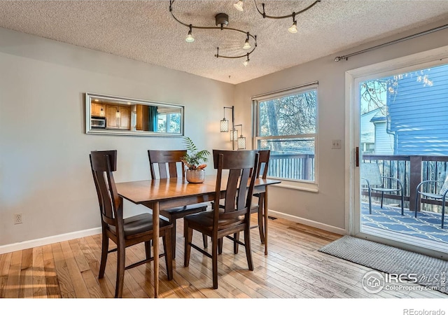 dining space featuring a textured ceiling and light hardwood / wood-style flooring