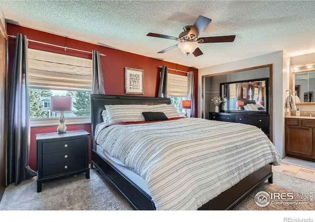 carpeted bedroom featuring ceiling fan, a textured ceiling, and connected bathroom