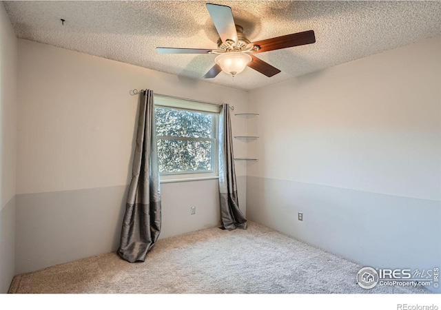 unfurnished room with ceiling fan, carpet, and a textured ceiling