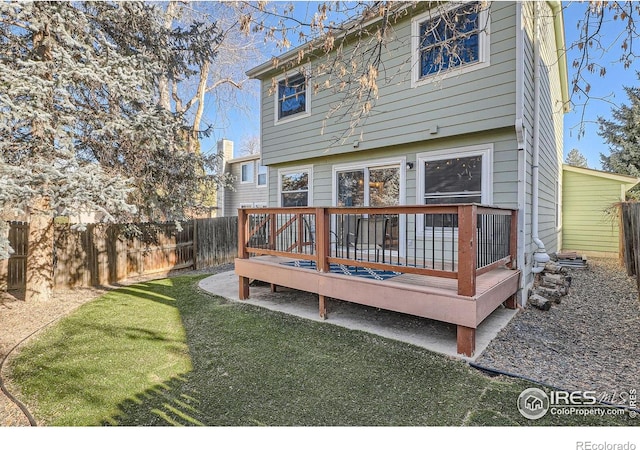 rear view of property featuring a lawn and a wooden deck