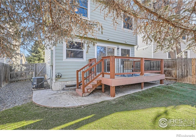 back of house with central AC unit, a deck, a yard, and a patio