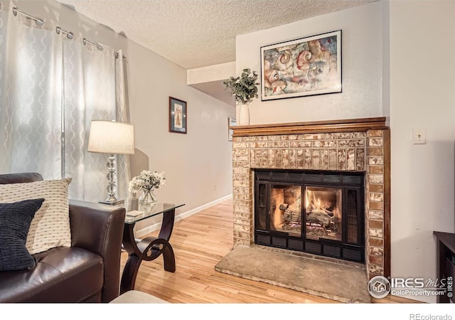 living area with hardwood / wood-style flooring, a fireplace, and a textured ceiling