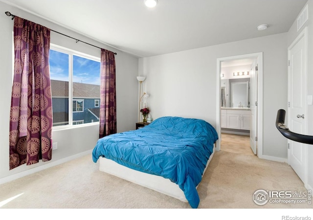 carpeted bedroom featuring ensuite bath