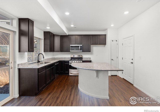 kitchen with a center island, stainless steel appliances, dark hardwood / wood-style floors, and sink