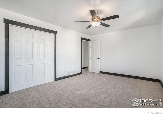 unfurnished bedroom with ceiling fan, a closet, and light colored carpet