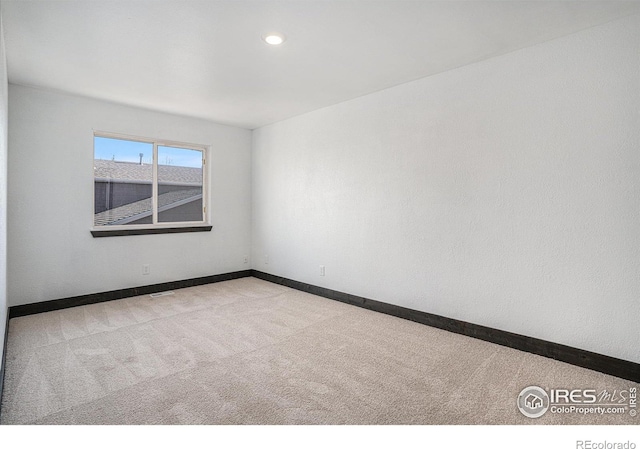 unfurnished room featuring light carpet