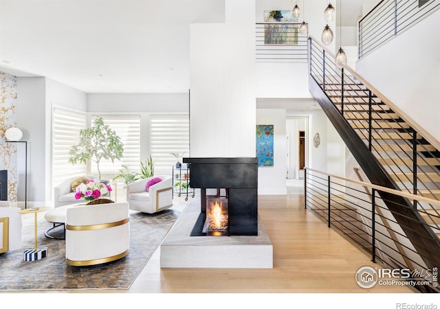 living room with a multi sided fireplace and wood-type flooring