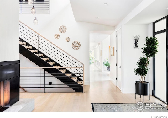 stairway featuring hardwood / wood-style flooring and vaulted ceiling