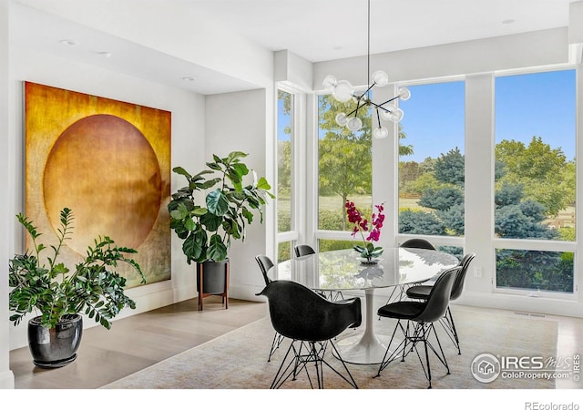 dining area with light hardwood / wood-style flooring and a chandelier