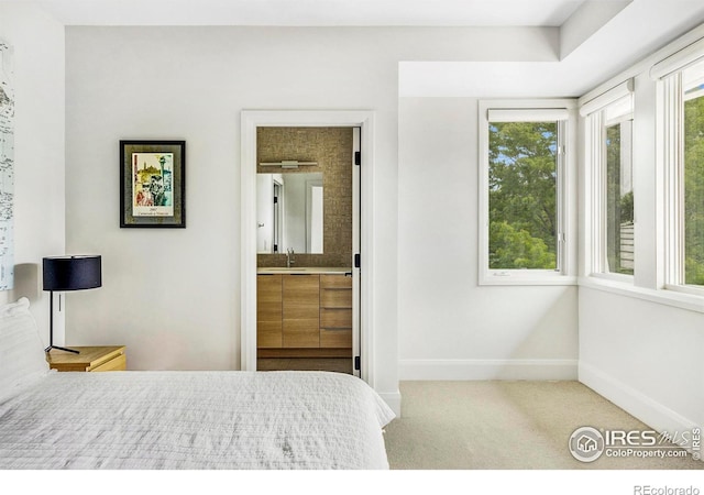 bedroom featuring light colored carpet, sink, and connected bathroom