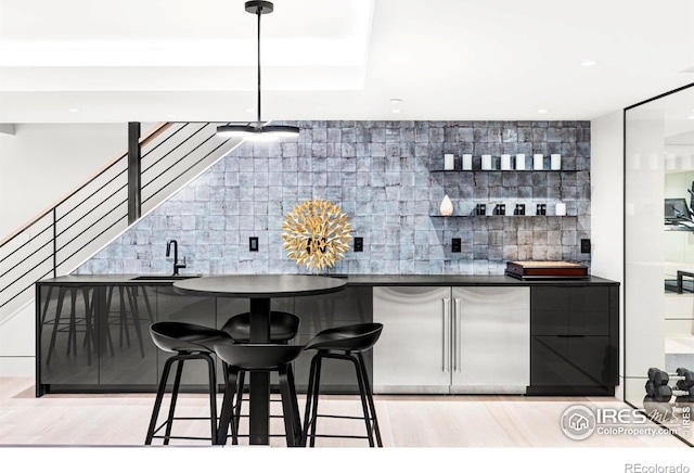 bar featuring high end fridge, sink, and tasteful backsplash