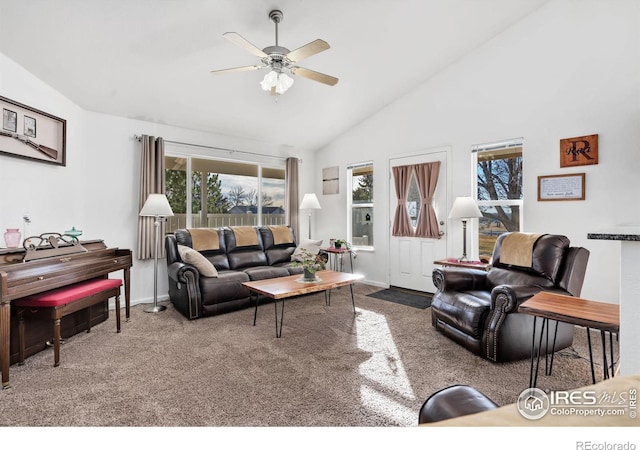 carpeted living room with ceiling fan and high vaulted ceiling