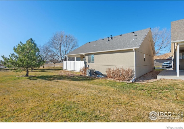 back of property with a lawn and central AC unit