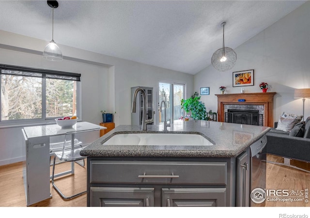 kitchen with sink, an island with sink, and pendant lighting