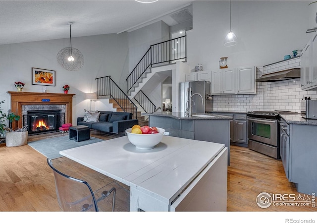 kitchen featuring decorative backsplash, appliances with stainless steel finishes, decorative light fixtures, and exhaust hood