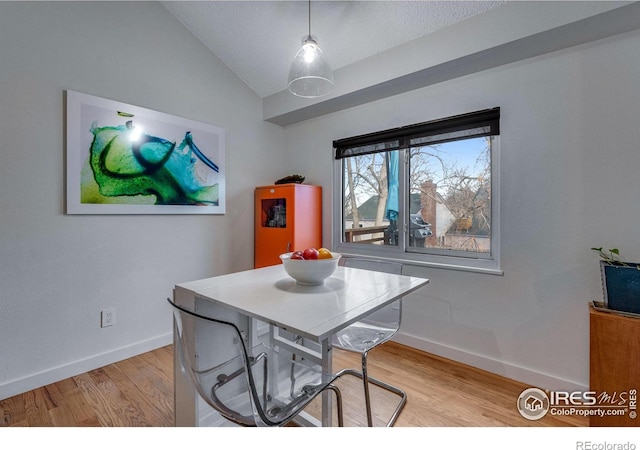 dining area with light hardwood / wood-style floors and lofted ceiling